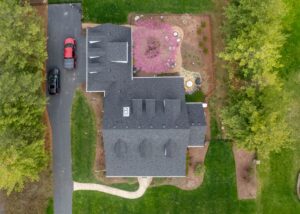 Aerial top view of home with new roof, showing uniform shingles, proper installation, and fall-ready exterior renovation for durability and curb appeal.