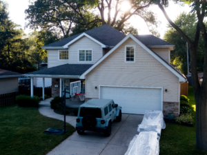 Two-story home with new siding, showcasing material options like vinyl or fiber cement, highlighting durability, curb appeal, and energy efficiency benefits.