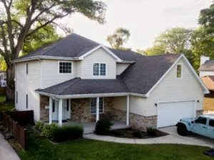 Front view of a renovated home with new roof, updated siding, stone accents, and landscaped yard enhancing curb appeal and exterior appearance.